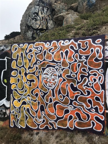 A painting in front of a rocky landscape.