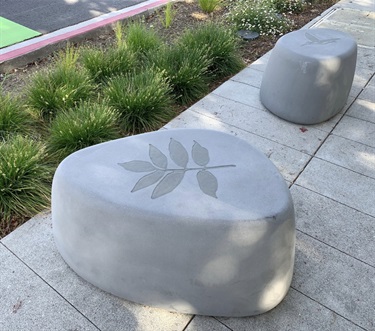 Two smooth grey sculptures printed with a plant motif.