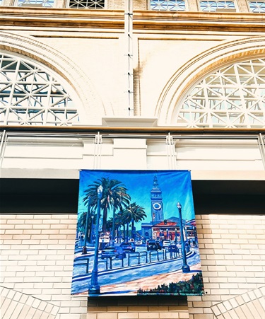 A banner with artwork on the side of a building.