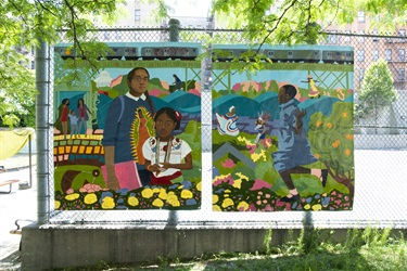 Paintings attached to a chain link fence. 