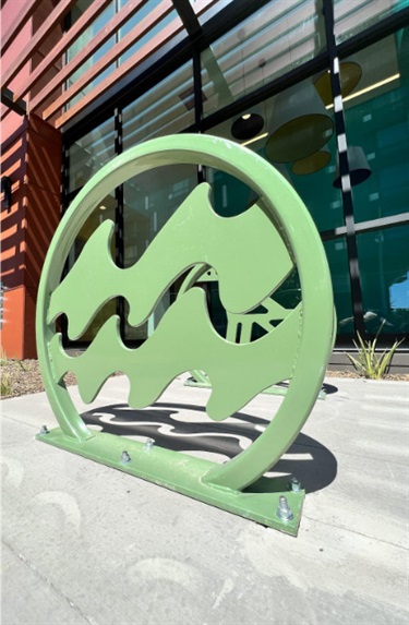 A green sculpture in front of a building. 