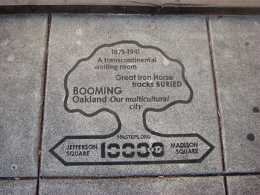 A tree-shaped marker in the concrete of the sidewalk.
