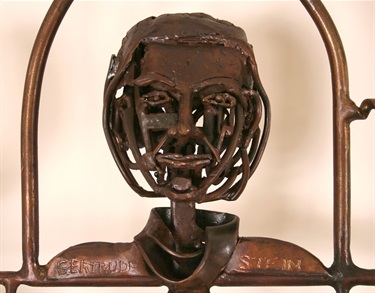A detail of a bust on a steel gate incorporating found objects.
