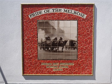 A mosaic with printed tiles on the wall of a fire station. 