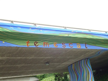 A mural painted on the underside of an overpass. 