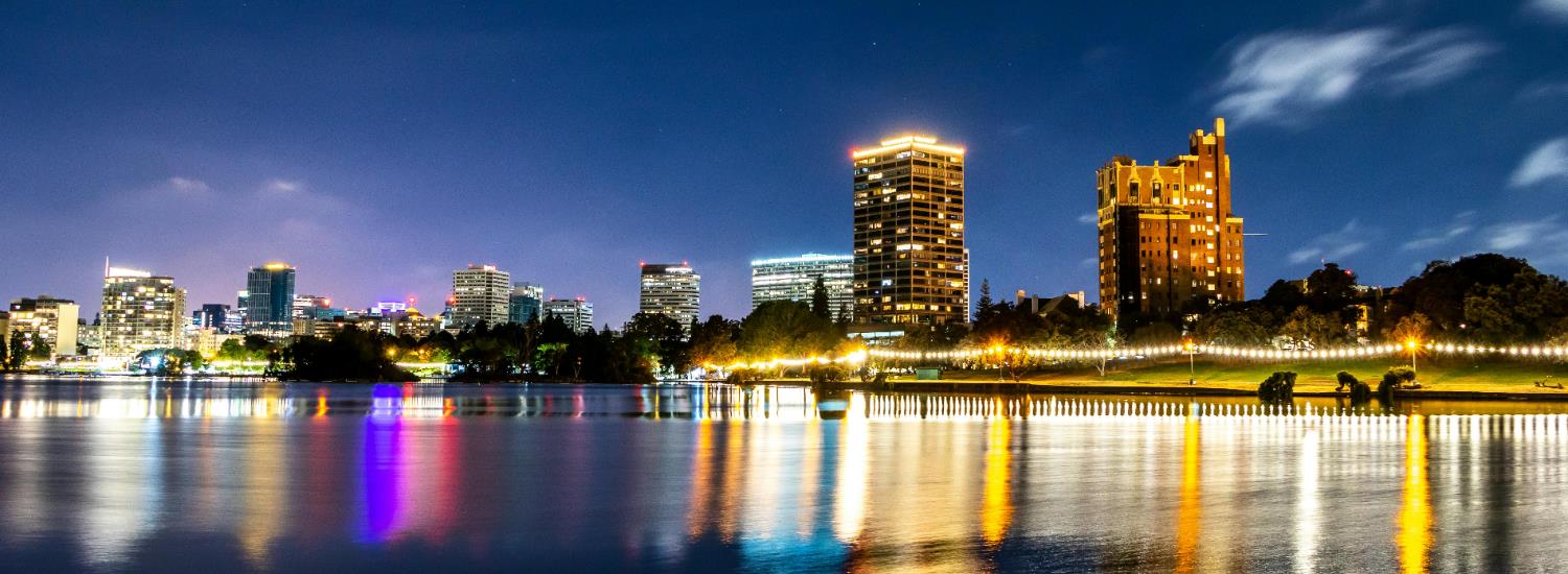 Lake Merritt at night with the water reflecting lights from the building