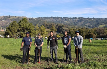 group of five people from oakland fire smiling with tools at king estate open space