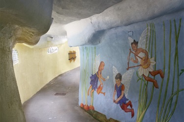 The inside of a children's play area in Fairyland with murals on the walls. 