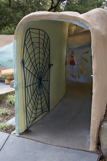 The entrance to a children's play area at Fairyland that has a gate with a spider web design.
