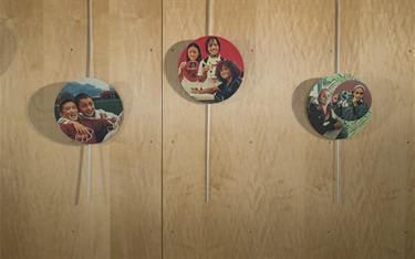 A detail of artwork printed on medallions suspended along a wall inside a recreation center.