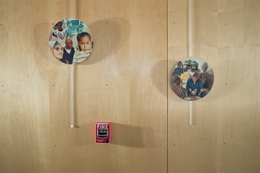 A detail of artwork printed on medallions suspended along a wall inside a recreation center.
