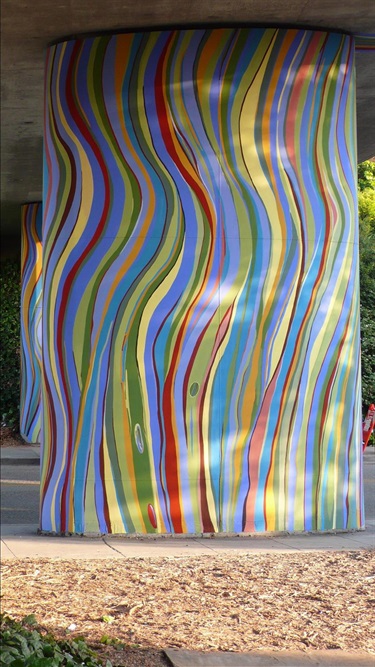 A mural painted on a podium on the underside of an overpass.
